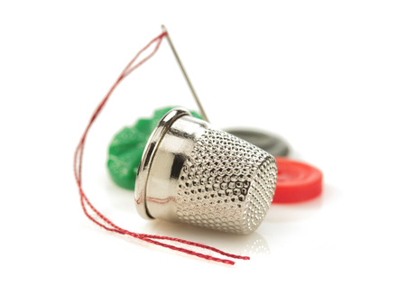 sewing thimble and thread with needle isolated on white background