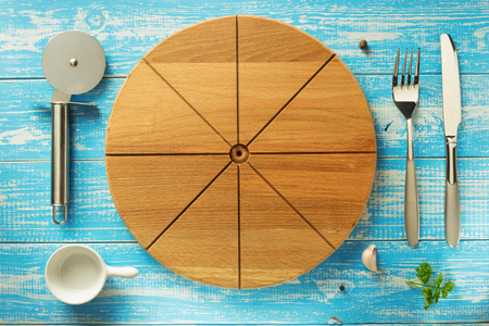 pizza cutting board and utensils at wooden tableの写真素材