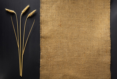 ears of wheat and cloth  on wooden backgroundの写真素材