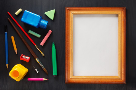 paint supplies and frame on black wooden backgroundの写真素材