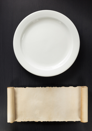 plate and scroll on wooden background