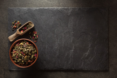 bowl of  of dry tea and scoop at slate backgroundの写真素材