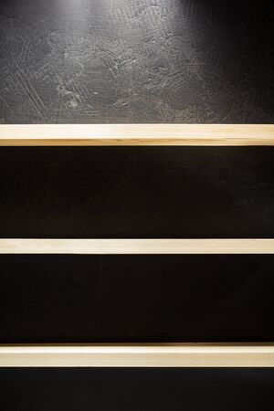 shelf and black wall on wooden backgroundの写真素材