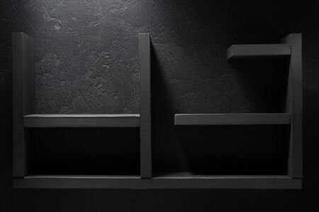 wooden shelf on black wall backgroundの写真素材
