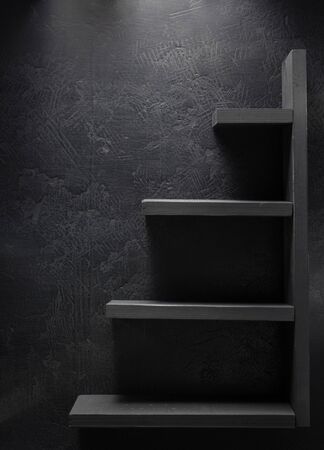 wooden shelf at black wall  backgroundの写真素材