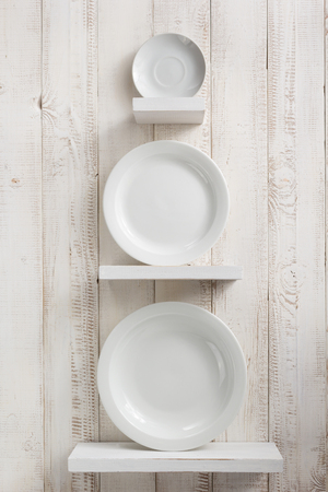 plate at kitchen shelf on white wooden backgroundの写真素材