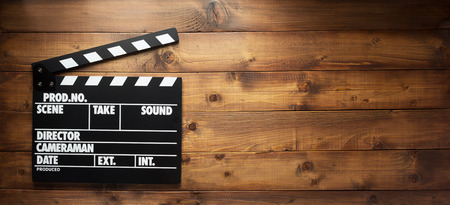 movie clapper board at wooden background texture, top view