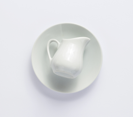 empty cream jug at plate on white background, top viewの写真素材