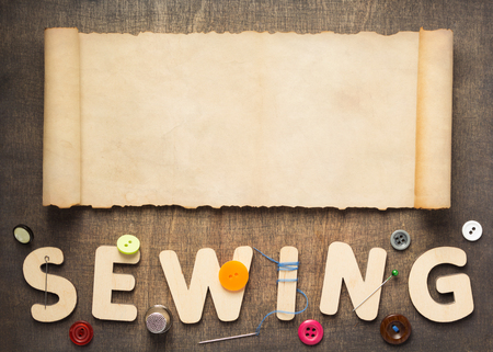 sewing tools and letters on wooden table background, top viewの写真素材