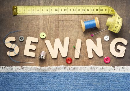 sewing tools and letters on wooden table background, top viewの写真素材