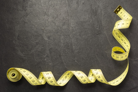 tape measure on slate stone background, top viewの写真素材