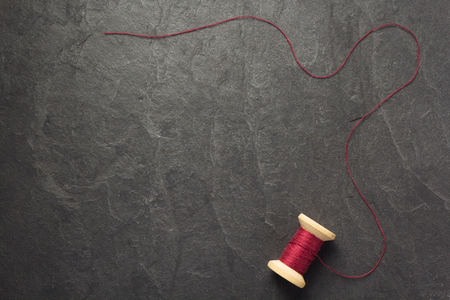 spool of thread on slate stone background, top viewの写真素材
