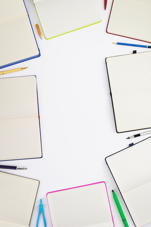 paper notebook and school supplies at white backgroundの写真素材