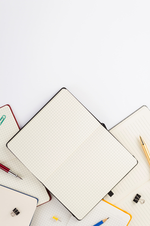 paper notebook and school supplies at white backgroundの写真素材