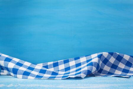 cloth napkin at blue rustic table in front, wooden plank board backgroundの写真素材