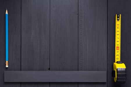 tape measure and pencil at plank wooden board table background textureの写真素材