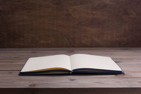 notepad or paper notebook at wooden table background surface tableの写真素材