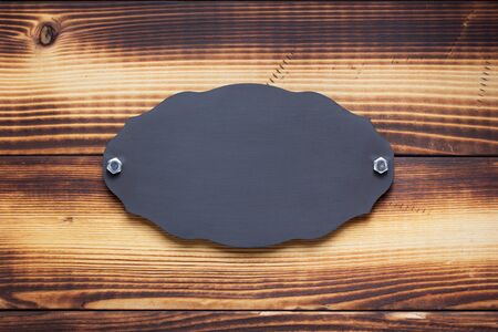 nameplate or wall sign with screws on  wooden backgroundの写真素材