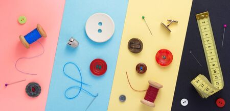 sewing tools and accessories at paper background texture, top view