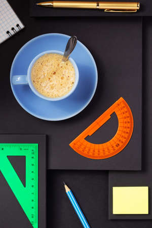 office supplies and cup of coffee at abstract black paper backgroundの写真素材