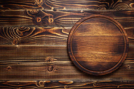 pizza cutting board or tray at wooden background texture, top viewの写真素材