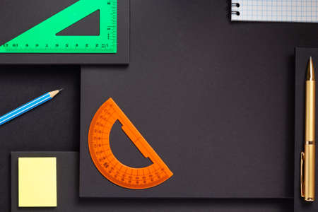 school accessories and office supplies at abstract black paper background