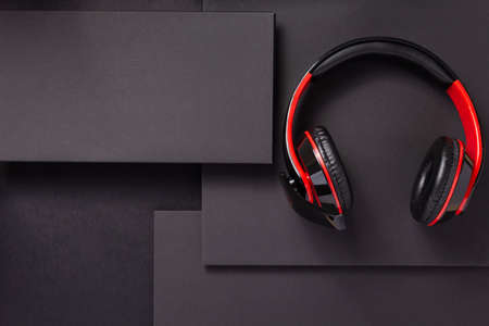 wireless earphones or  headphones at abstract black paper background, minimalism concept styleの写真素材