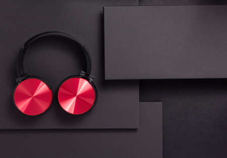 wireless earphones or  headphones at abstract black paper background, minimalism concept style