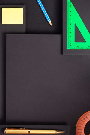 school accessories and office supplies at abstract black paper background