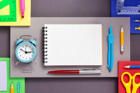 school accessories and office supplies at abstract colorful paper background