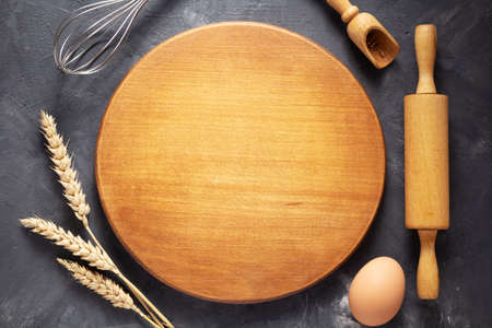 Pizza or bread cutting board with bakery ingredients for homemade baking on table. Food recipe concept at stone background texture with copy space. Flat lay top viewの写真素材