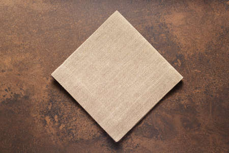 Folded burlap linen fabric  tablecloth at stone surface of table. Hessian sack  napkin texture background. Top viewの写真素材
