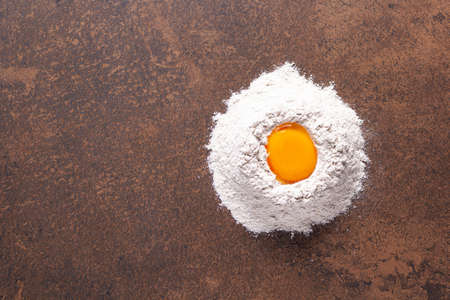 Flour food and egg as bakery ingredients for homemade bread baking on table. Recipe concept  top view at stone background texture with copy space, flat lay conceptの写真素材