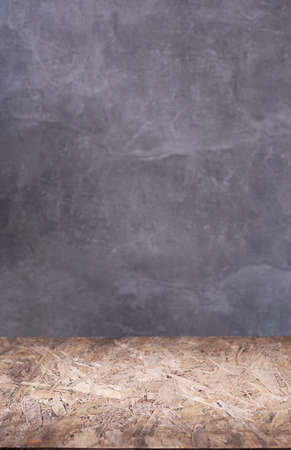 Osb or chipboard shelf and table near concrete wall background. Chipboard top of table or tabletop
