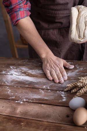 Baker man kneading dough and bakery ingredients for homemade bread cooking on table. Bakery concept...