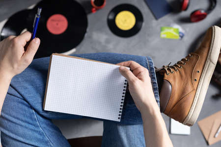 Men's hand holding pen or pencil and notebook and leg in jeans. Study or art music life style...