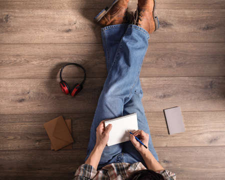 Men's hand holding pencil and notebook. Student male hand writing or drawing by pencilの写真素材