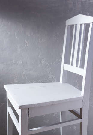 Old retro white wooden chair near concrete wall background. Miimalism concept of room interiorの写真素材