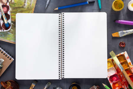 Sketchbook at paintbrush and tubes with painter tools at abstract table background texture. Art painter concept and paint brushの写真素材