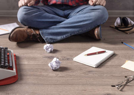 Man sitting on floor thinking idea. Writer or screenwriter with typewriter. Creative inspiration...