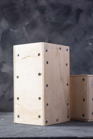 Wooden cube or plywood box near wall background texture. Abstract art or construction concept of...