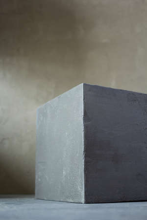 Concrete cube near wall background texture. Abstract art or construction concept of minimalism...