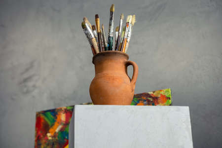 Paint brush in clay jug on table background texture. Paintbrush  painting and art still life. Abstract art conceptの写真素材