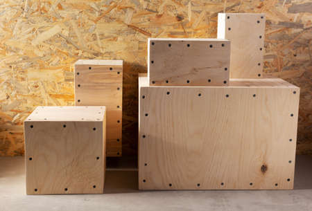 Stack of wooden cube or plywood box block near wall background texture. Abstract construction...