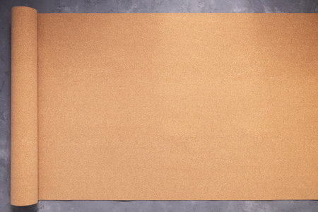 Roll of cork at concrete floor background texture. Corkboard at wall background with copy space