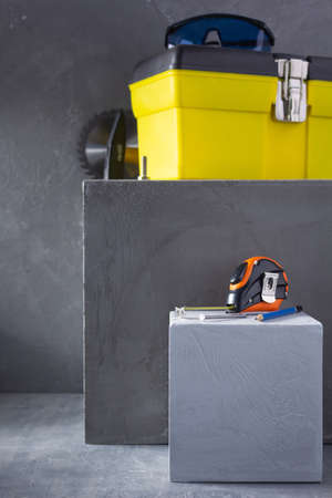 Construction tools at concrete cube or blocks near wall background texture. Tool kit and concept of...