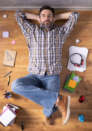 Man relaxing on floor thinking idea solitions. Man lying or student studying online lesson. Creative inspiration study conceptの写真素材
