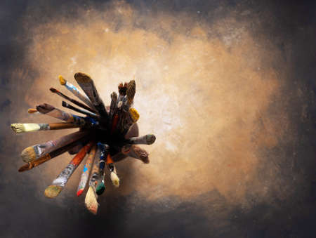 Paint brush in clay jug and art painting as abstract background texture. Paintbrush for oil painting as artistic paint still life. Abstract art conceptの写真素材