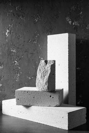 Aerated concrete block cube or bricks near plaster wall background texture. Construction concept of minimalism designの写真素材