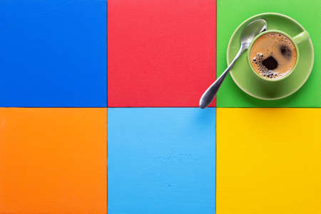 Cup of coffee and spoon at colorful abstract background texture. Coffee break time conceptの写真素材